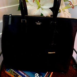 Kate Spade pocket book with zipper close, striped interior with inside pockets.